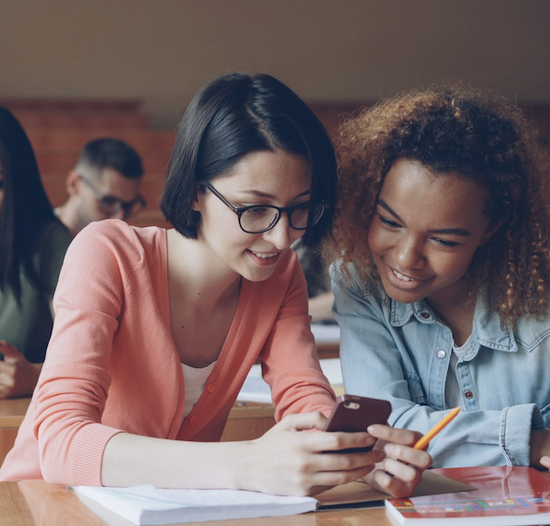 Two female students in a lecture theatre